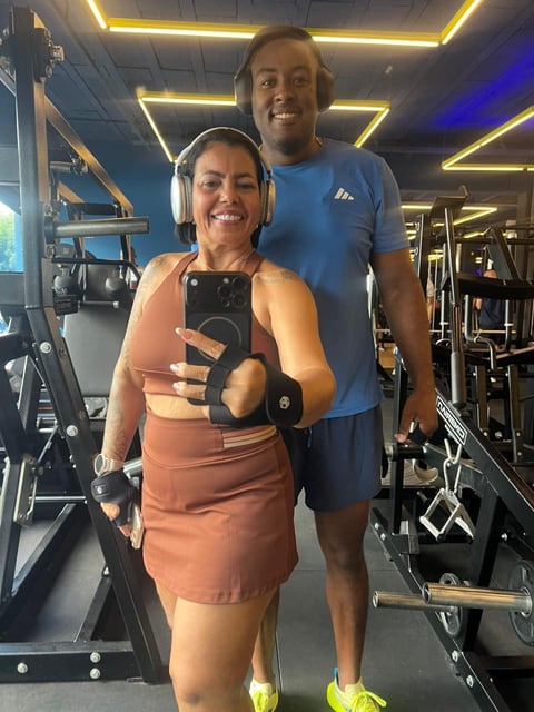 Paciente em academia, com o Dr. Saulo Silva, tirando foto no espelho